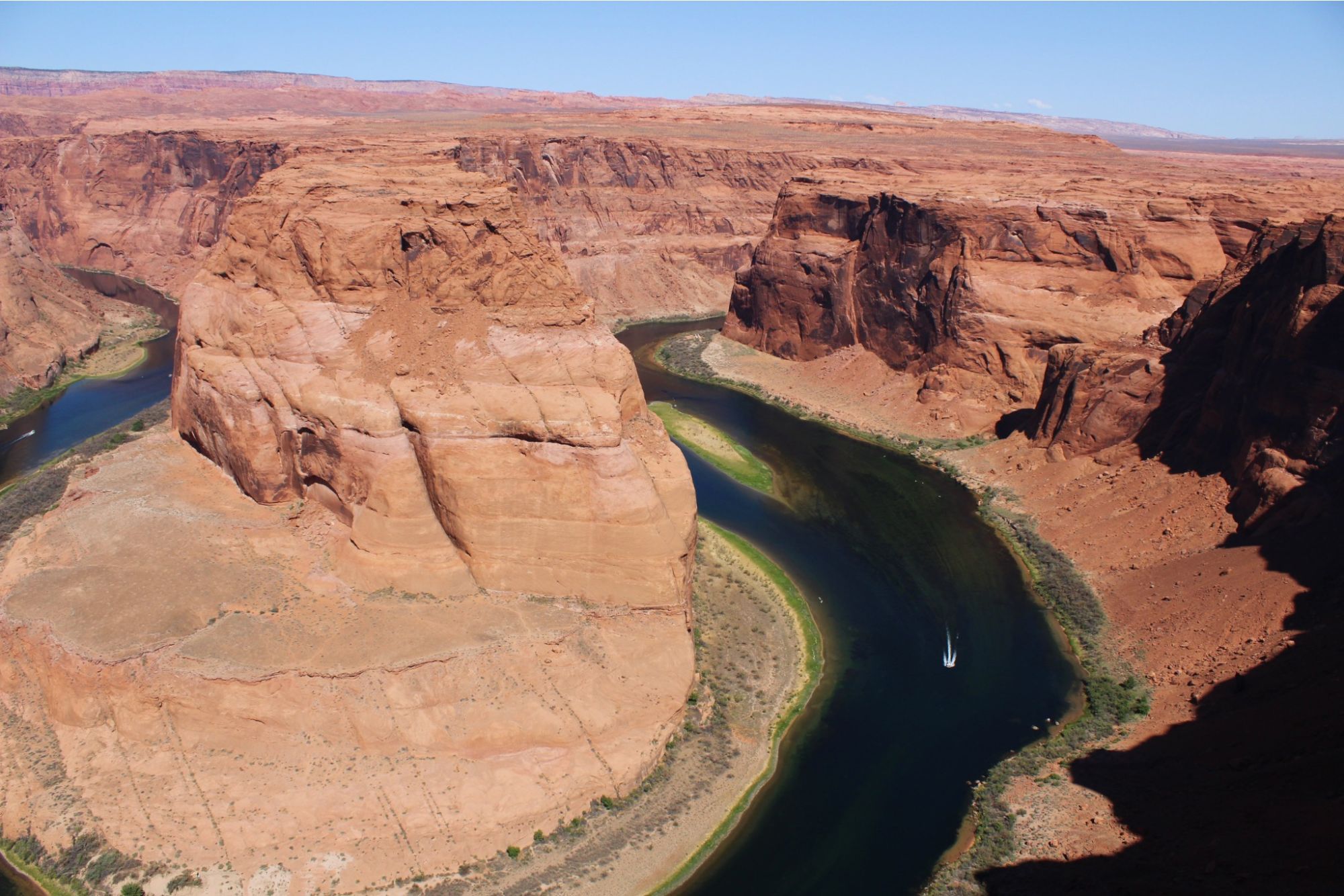 A river curving around a red rock canyon, seen from above