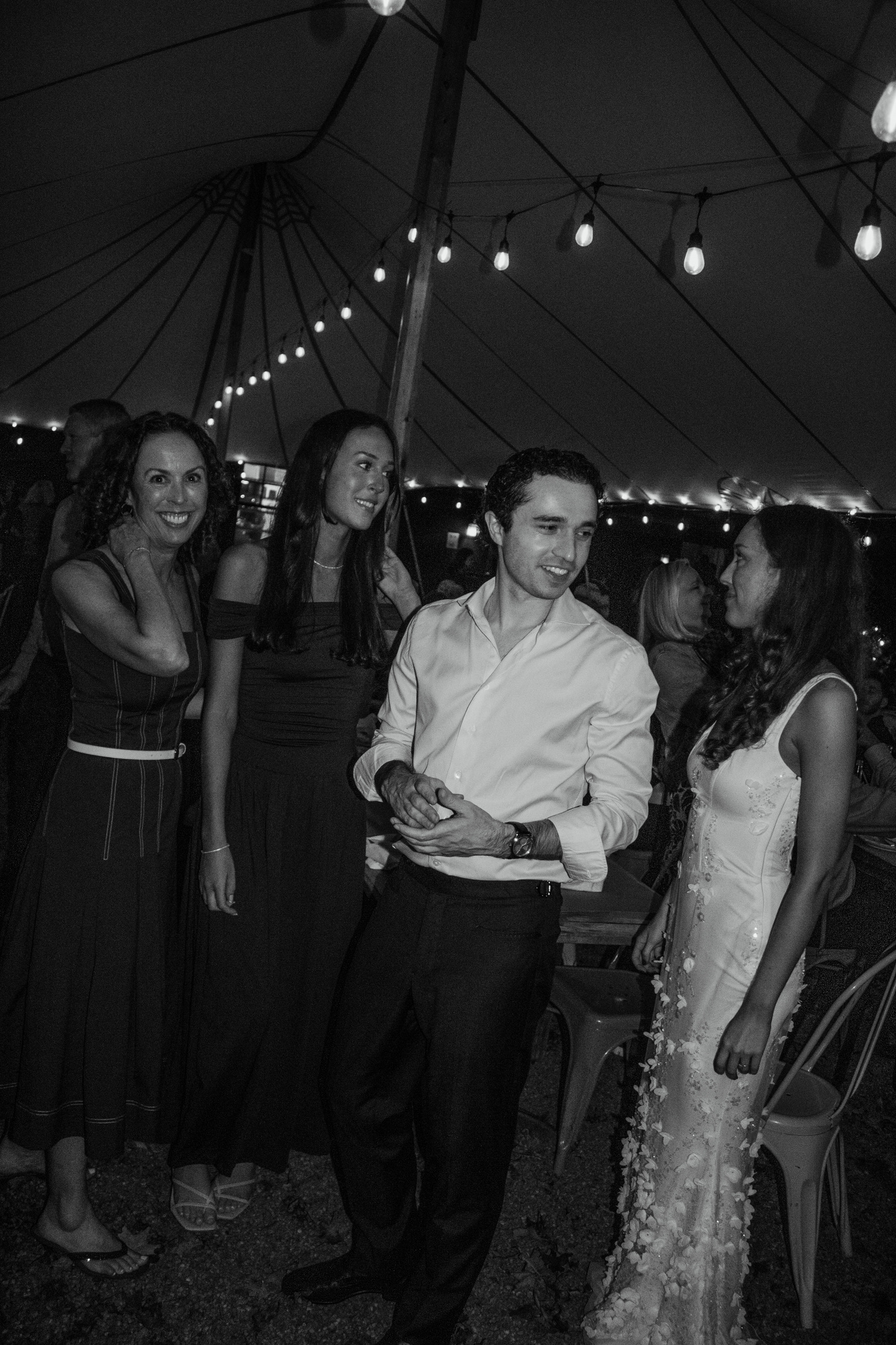 Black-and-white photo of the couple laughing with guests under the tent at Otto Pizza in Chester, Connecticut